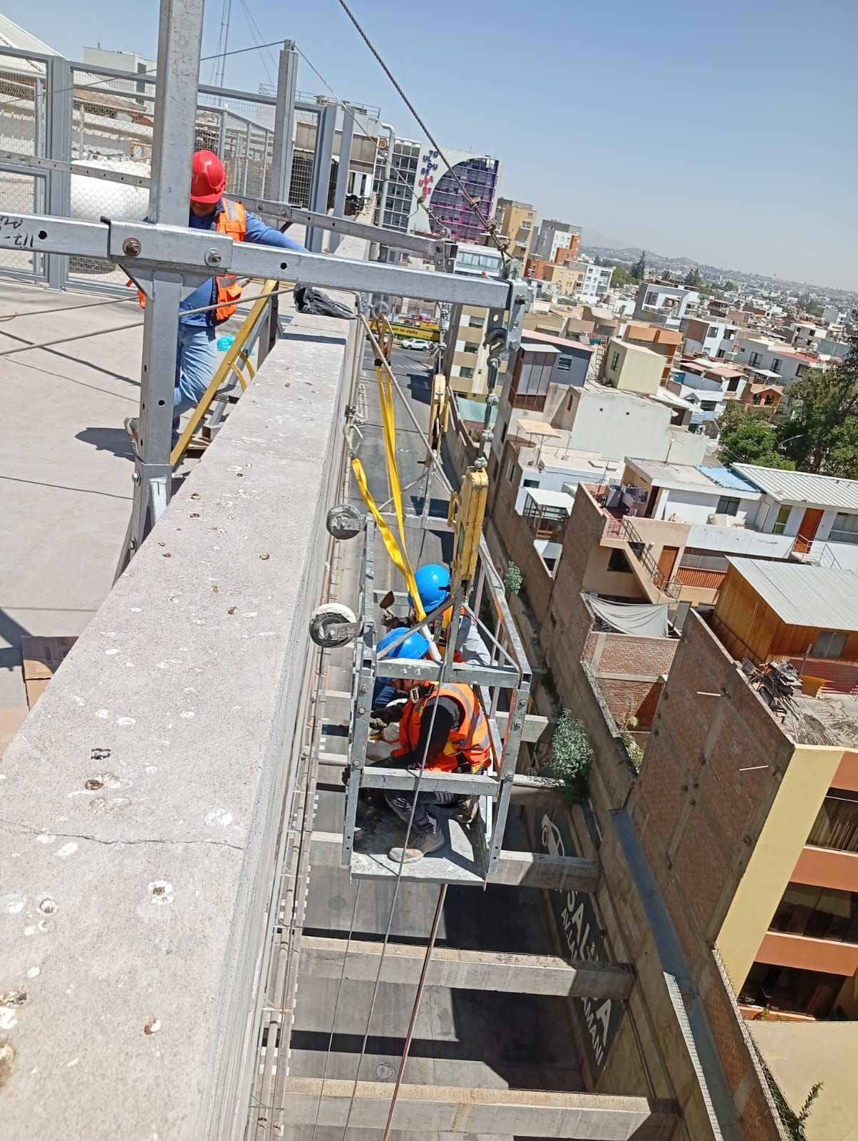 Un equipo con cascos de seguridad revisa planos alrededor de una mesa de conferencias en una oficina moderna.