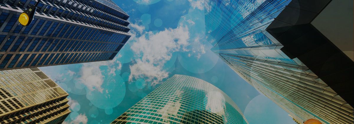 Skyscrapers viewed from below against a blue sky with clouds