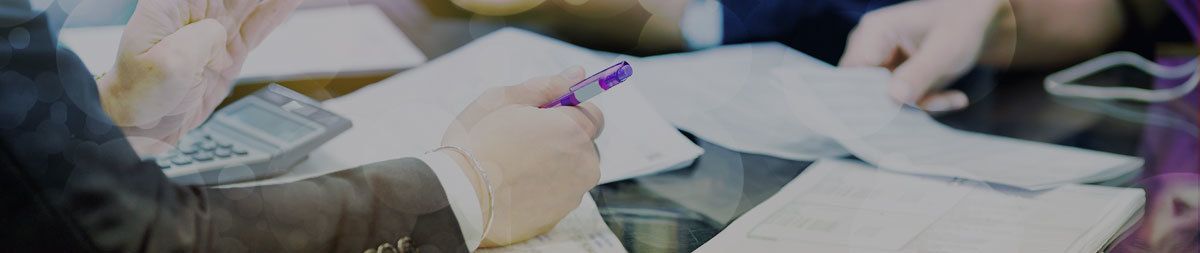 Hands reviewing papers at a meeting table with charts and coffee cups