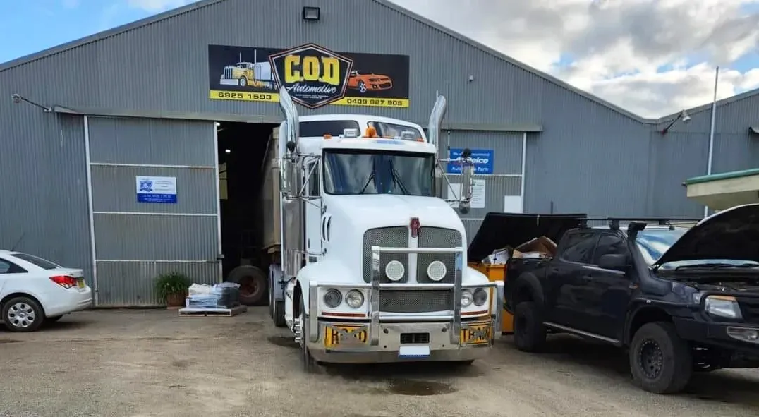 A White Semi-truck is Parked in Front of a Repair Shop — COD Automotive in Ashmont, NSW