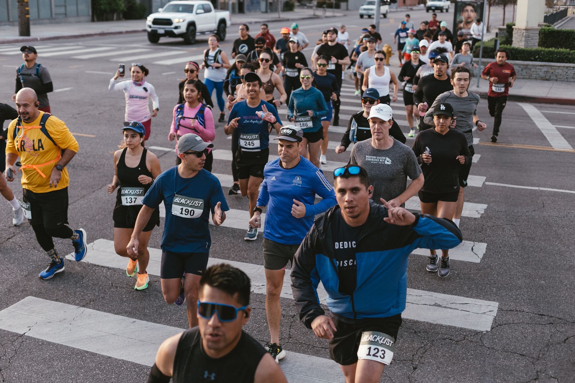 A group of people are running a marathon on a city street.