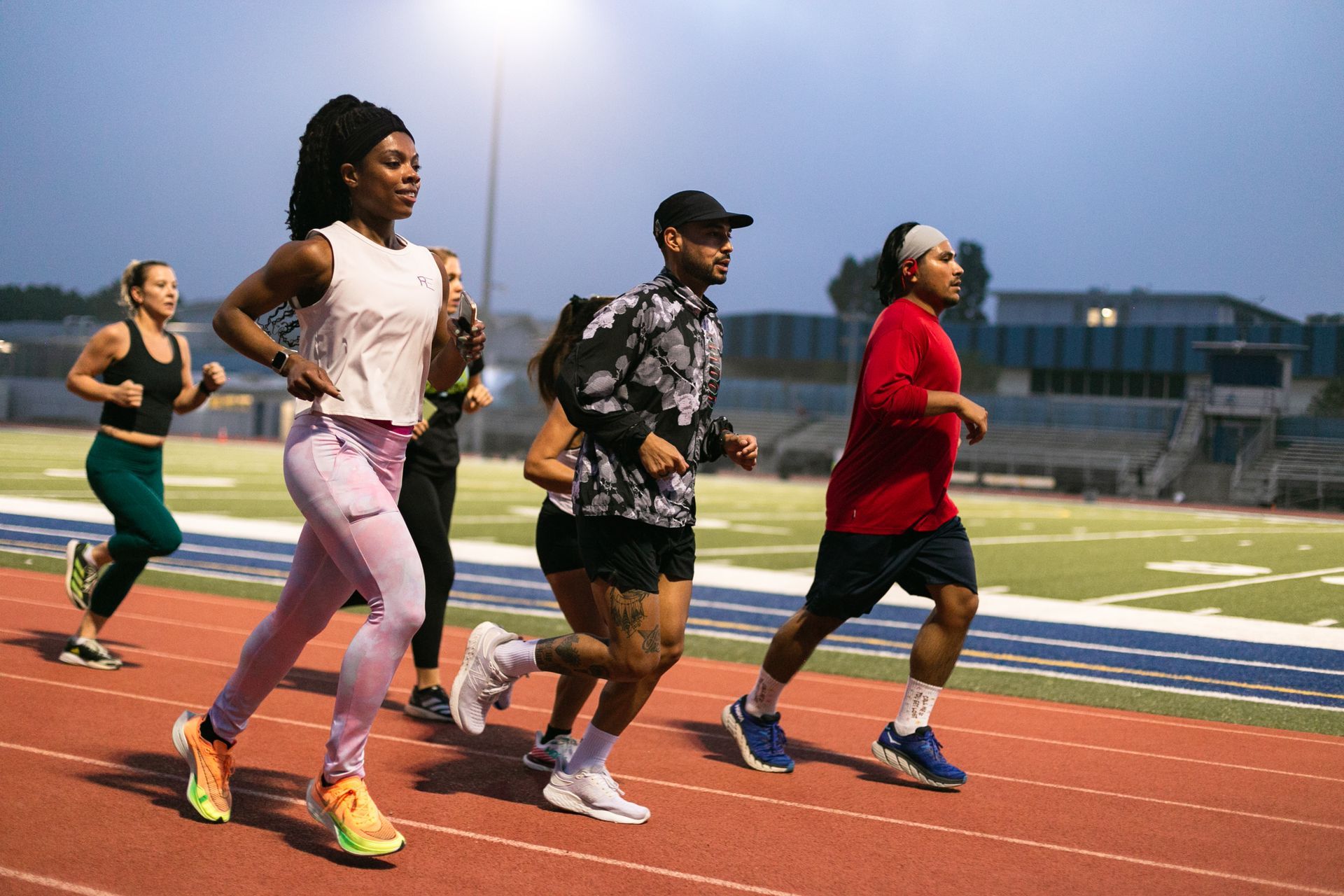 A group of people are running on a track.