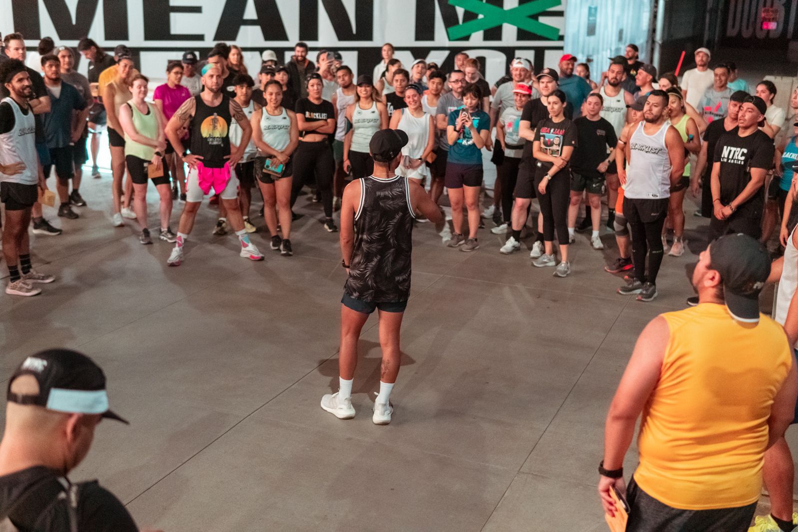 A large group of people are standing in a gym.
