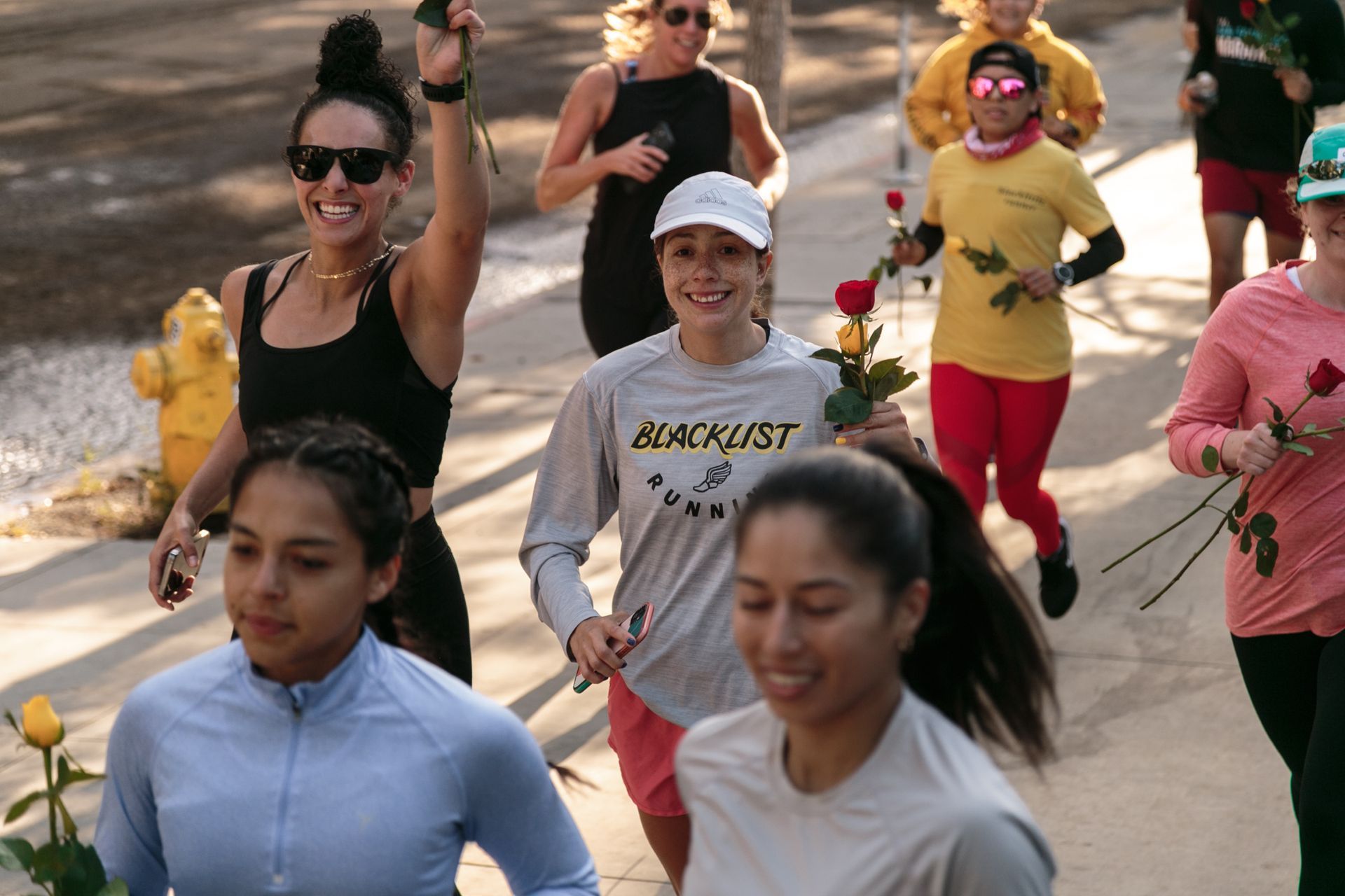 A woman wearing a blacklist shirt is running with other women