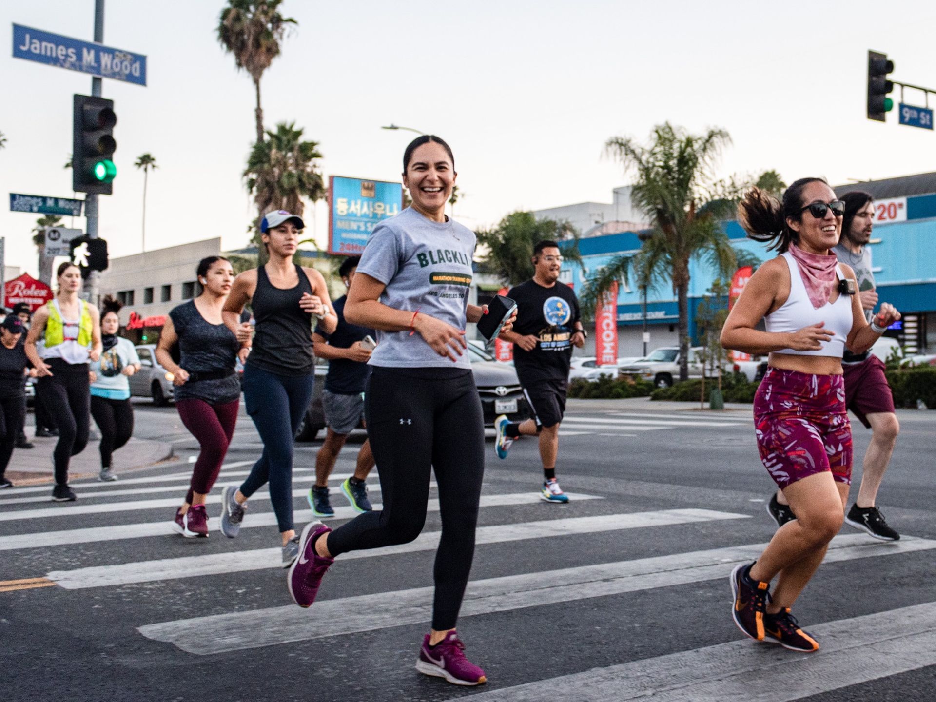 A group of people are running across a street.