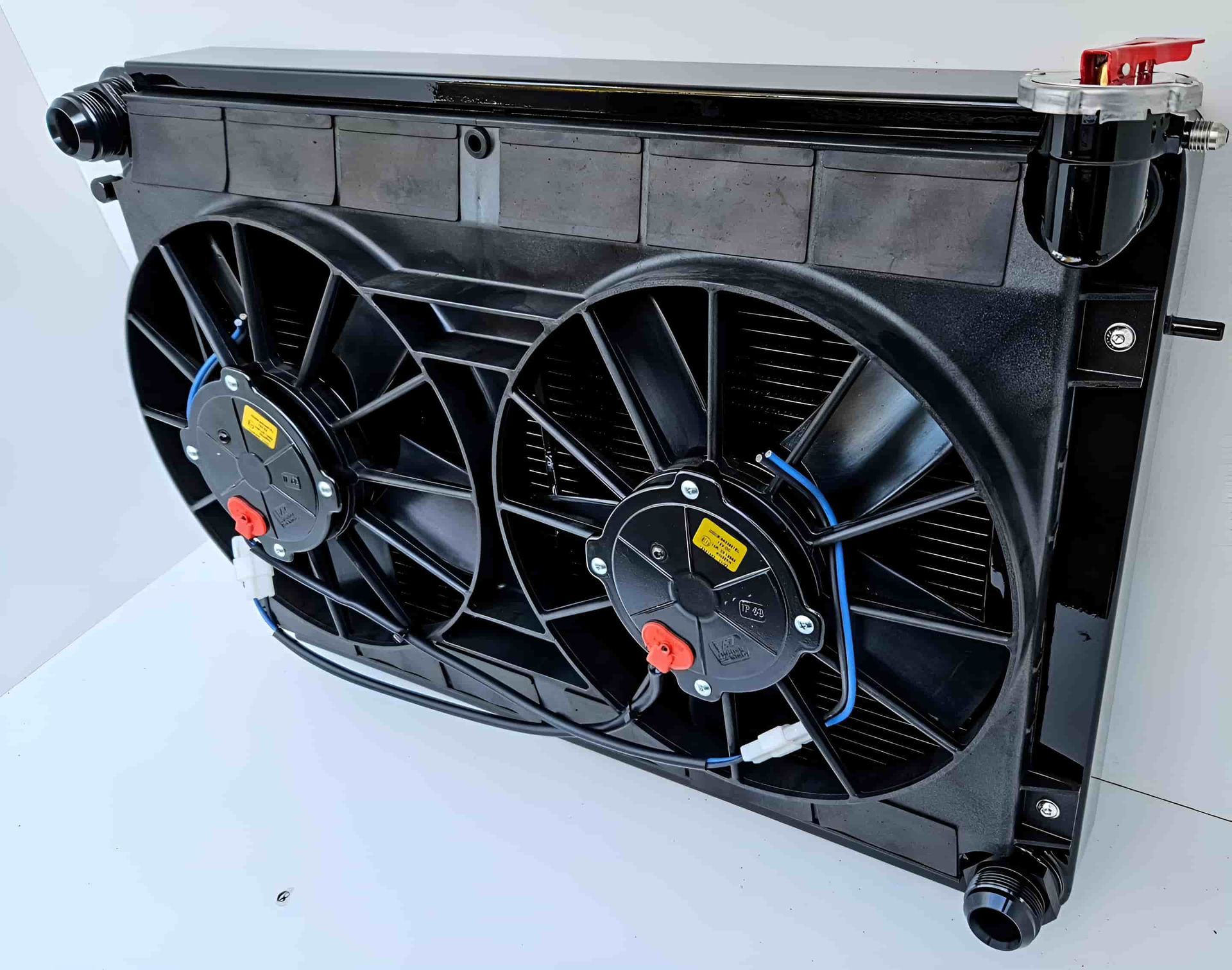 A Radiator With Two Fans Attached to It is Sitting on a White Surface — South Coast Radiators In Woonona, NSW