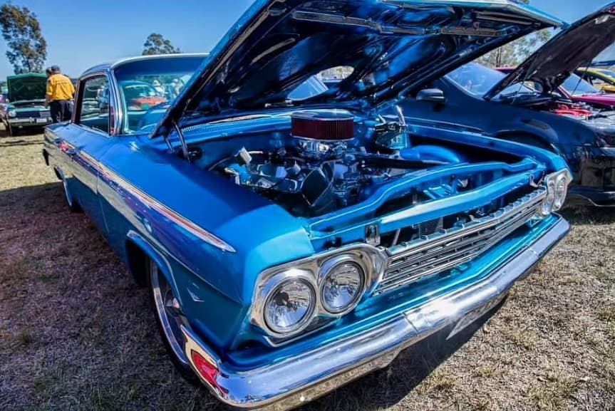 A Blue Car With the Hood Open is Parked in a Field — South Coast Radiators In Nowra, NSW