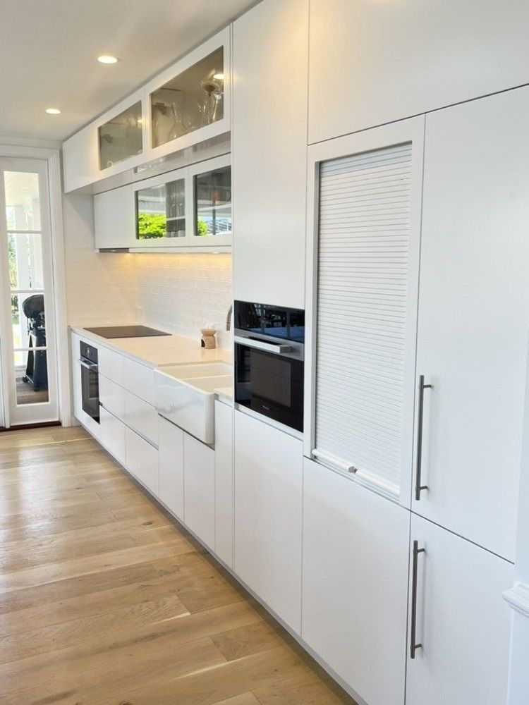 A Kitchen With White Cabinets and Wooden Floors — D Hinged Kitchens & Joinery in Main Arm, NSW
