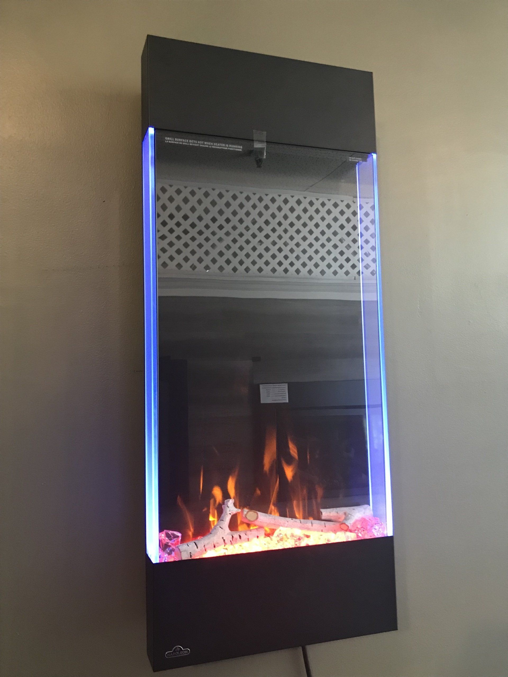 A wall mounted fireplace with a blue light behind it