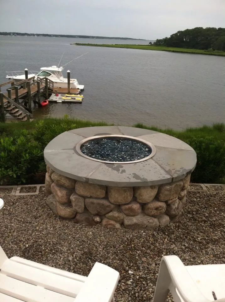 A fire pit with a view of a body of water