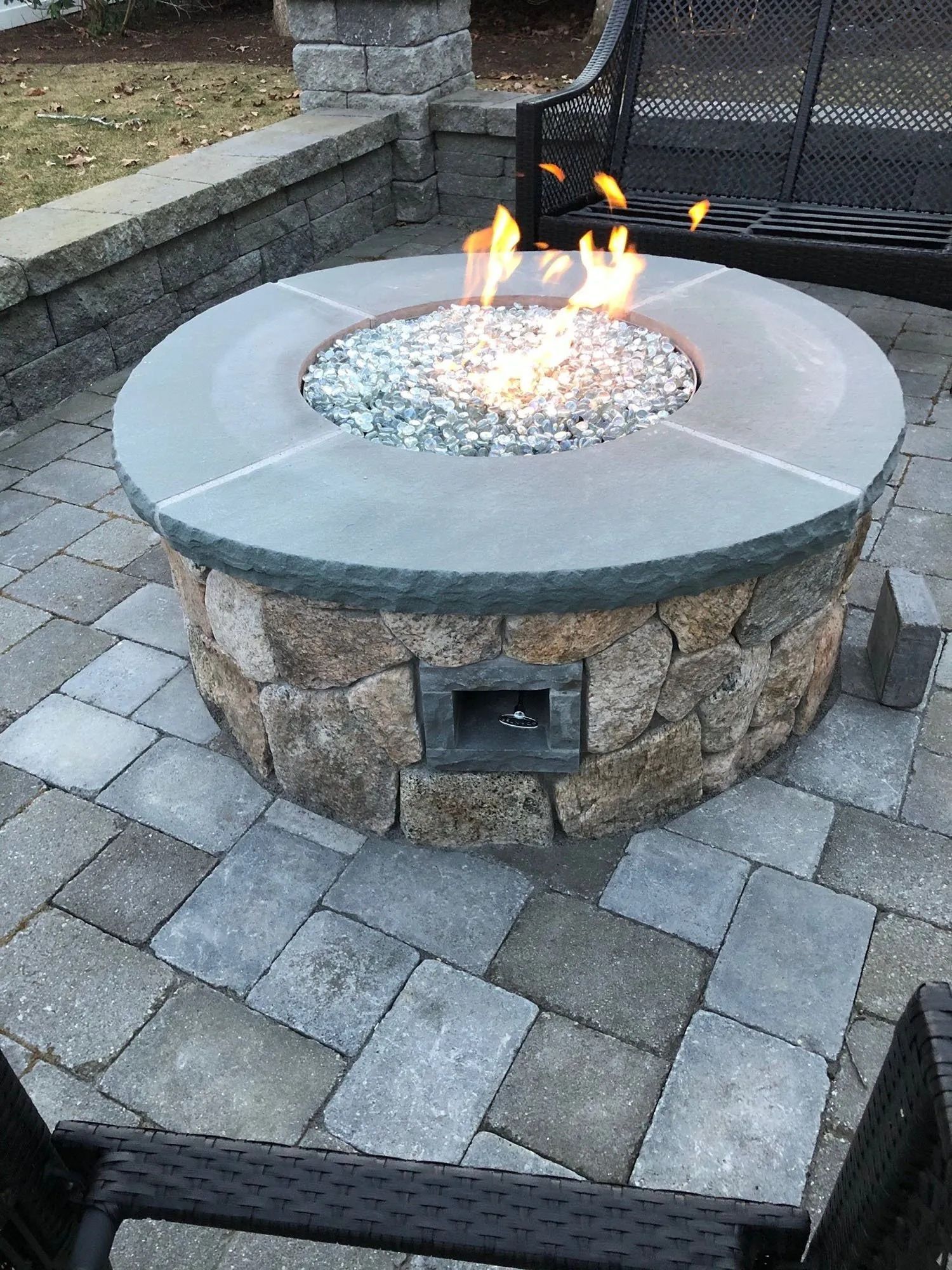 A fire pit is sitting on top of a brick patio.