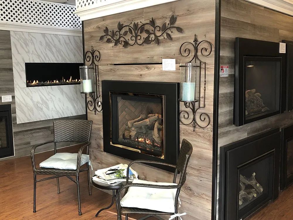 A living room with a fireplace , chairs and a table.