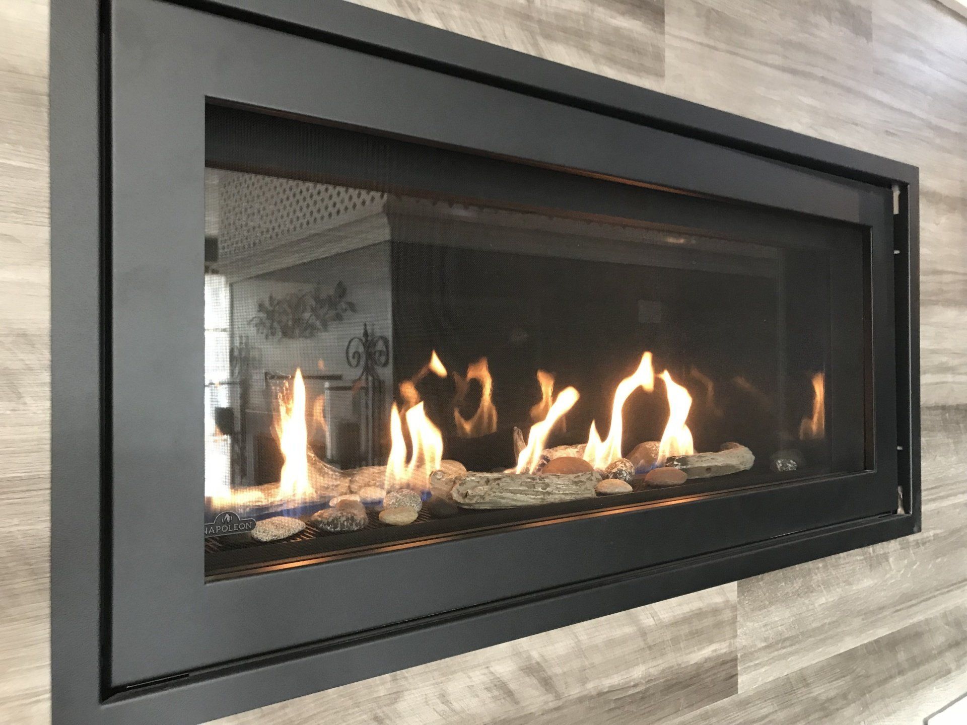 A fireplace with flames coming out of it is hanging on a wall.