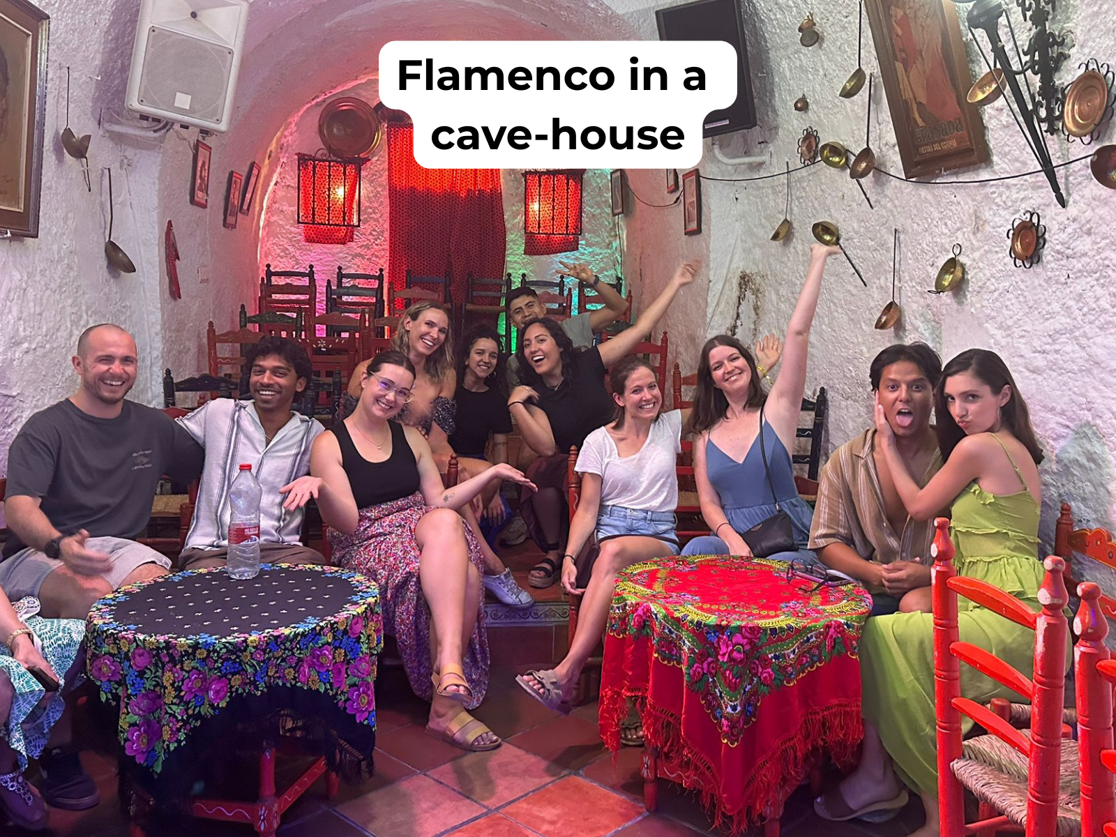 People in funny poses in a cave-house watching a Flamenco show