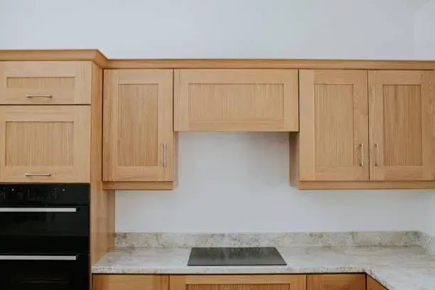 A kitchen with wooden cabinets and a black oven.