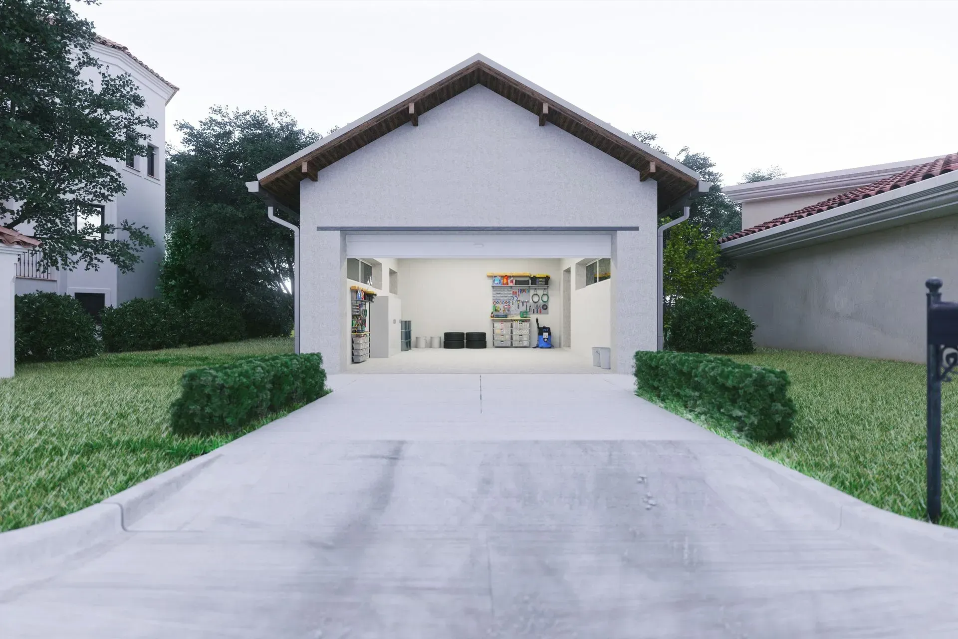 A white garage with the door open and a mailbox in front of it.