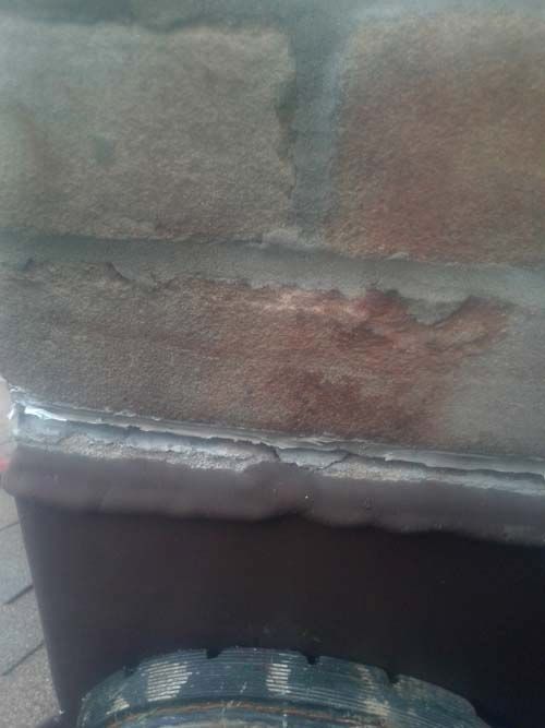 A close up of a tire on a brick wall.