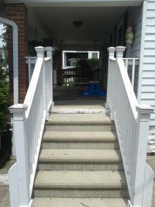 A set of stairs leading up to a porch of a house.