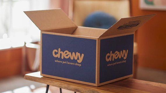 Chewy donations A cardboard box with the word chewy on it is sitting on a wooden table.