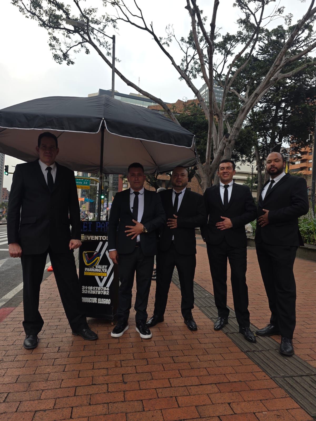 Cinco hombres vestidos con trajes negros de valet parking