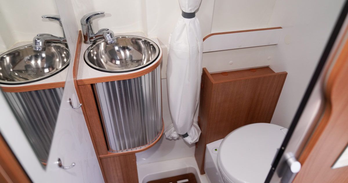 A bathroom with a toilet , sink and mirror