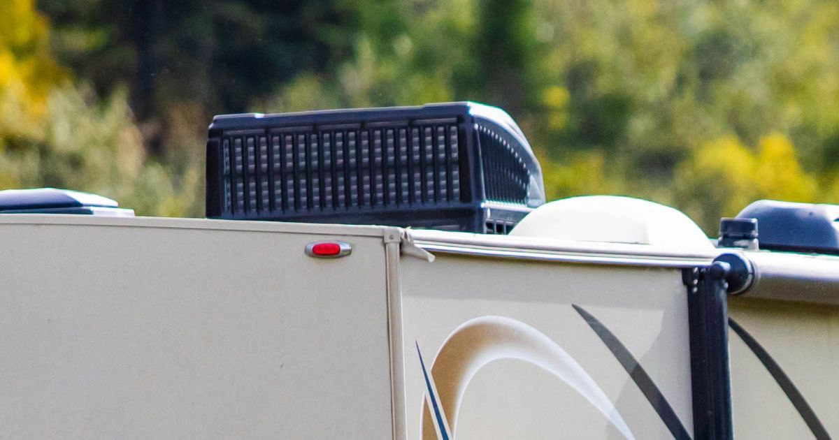 A rv trailer with a basket on top of it.