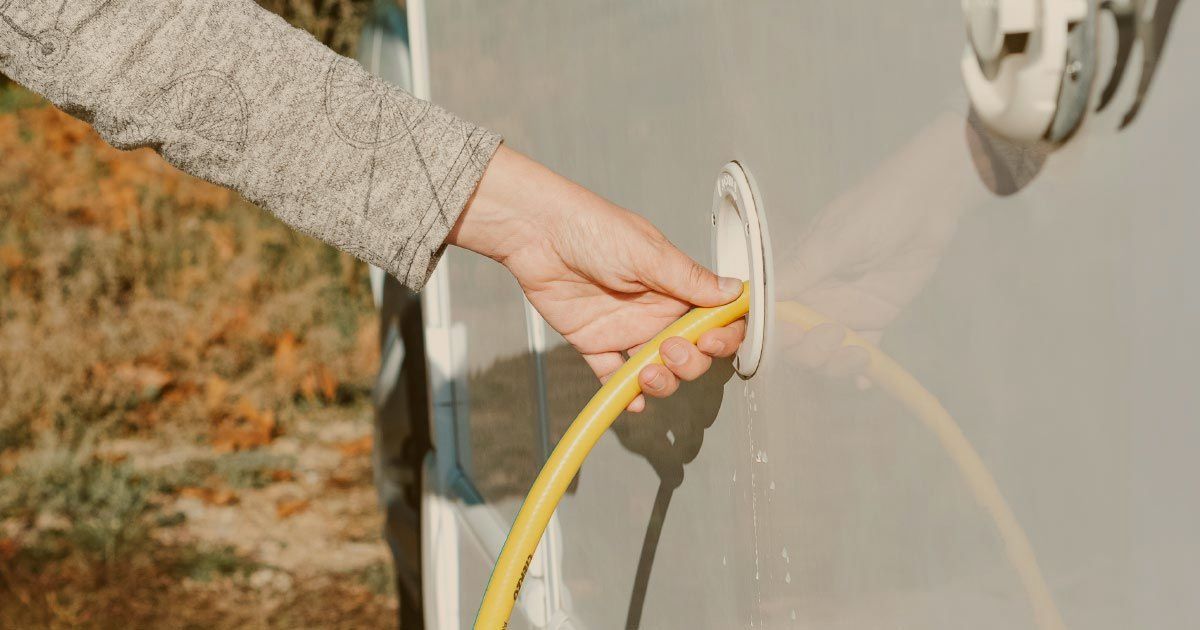 A person filling an rv water tank
