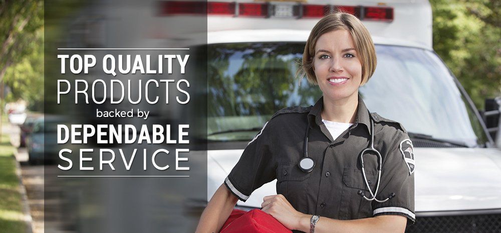 A female paramedic is standing in front of an ambulance.