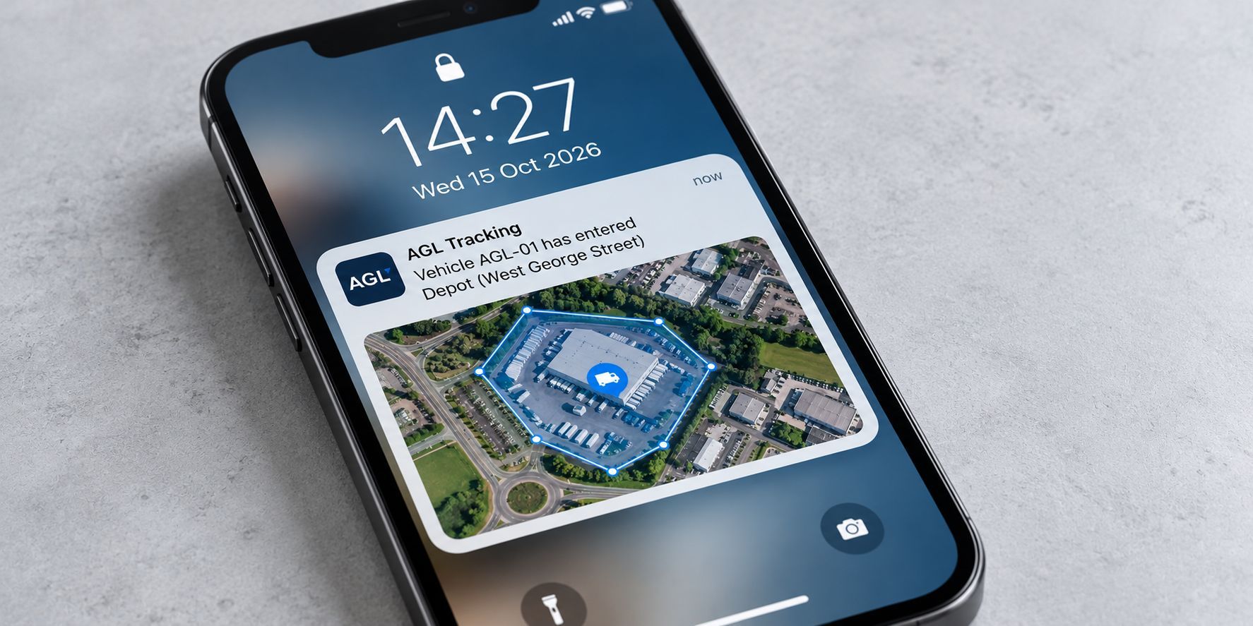 Smartphone displaying a GPS geofencing alert when a commercial vehicle enters a depot.