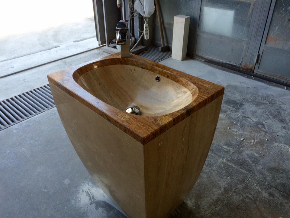 Bidet in legno con vaso e rubinetto integrati, situato in un laboratorio con pavimento grigio.