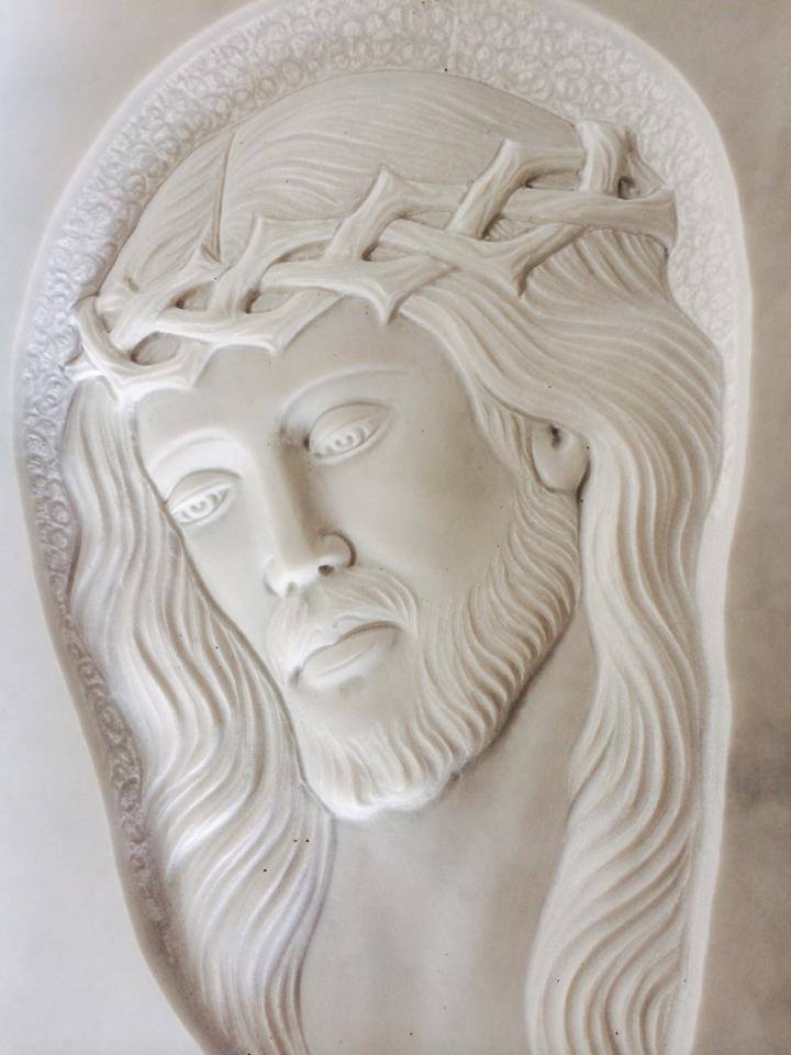 Bassorilievo raffigurante Gesù, con una corona di spine e un'espressione cupa.