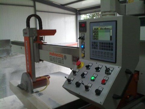 Macchina per il taglio della pietra CNC con pannello di controllo e braccio robotico.