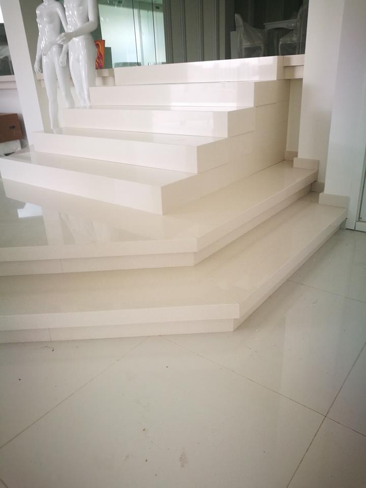 Scala in marmo bianco con pianerottolo in una stanza luminosa.