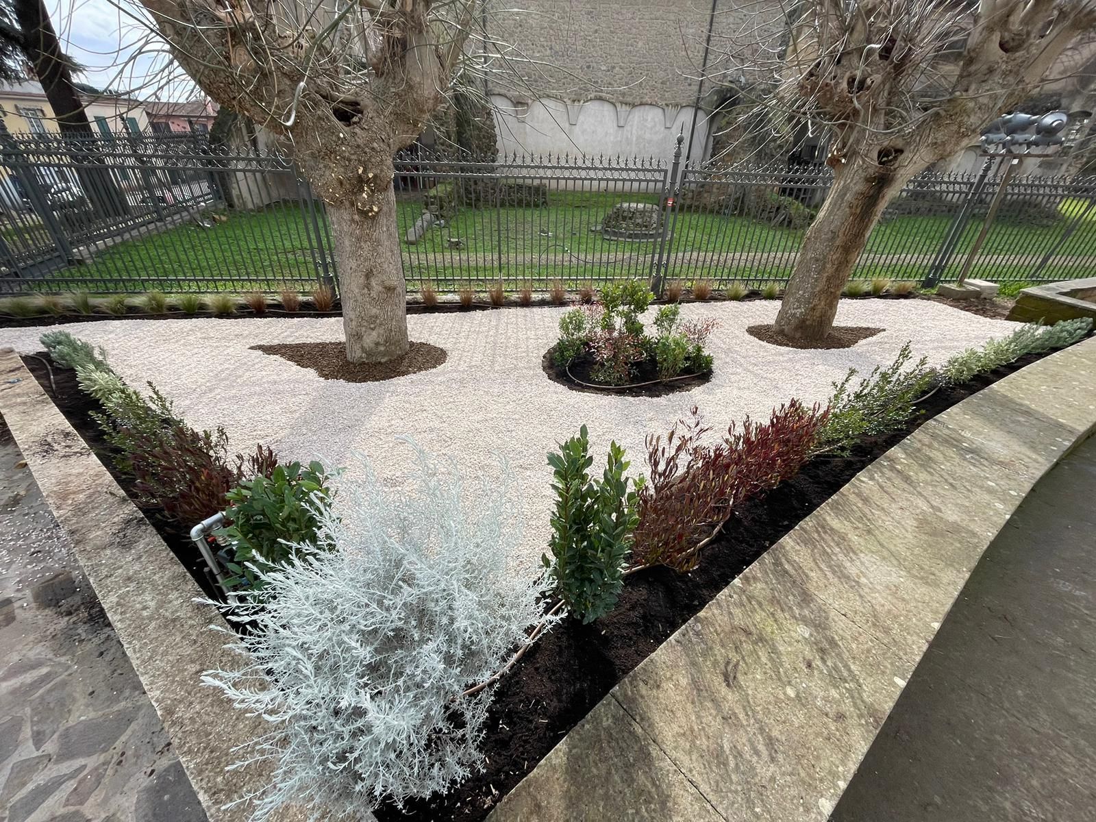 Impianto di irrigazione automatico in un giardino residenziale con prato verde e irrigatori in funzione.