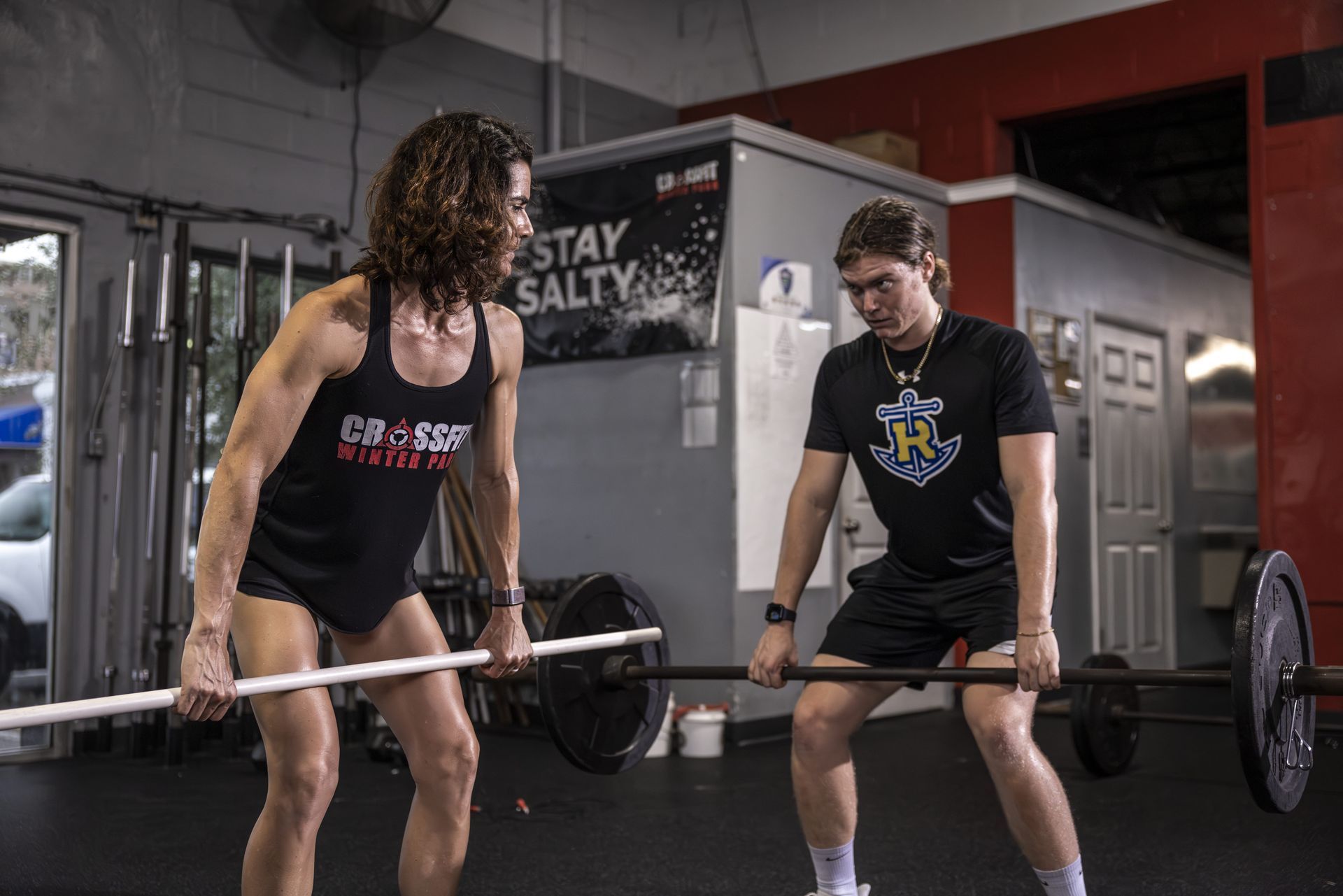 Two people lifting barbells in a gym in Winter Park, FL