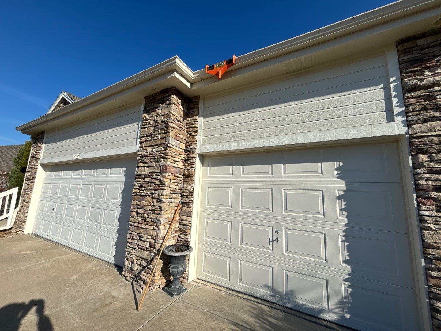 A couple of white garage doors on a brick building.