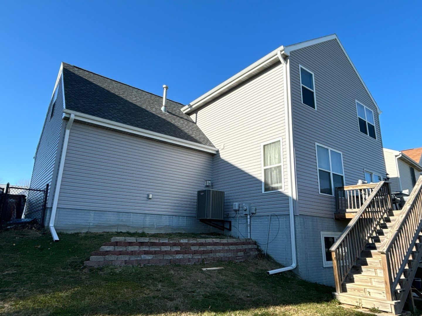 The back of a house with a deck and stairs.