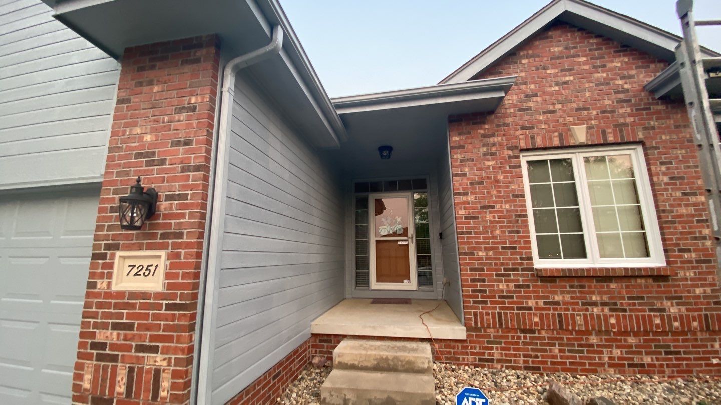 The front of a brick house with a garage and stairs leading up to it.