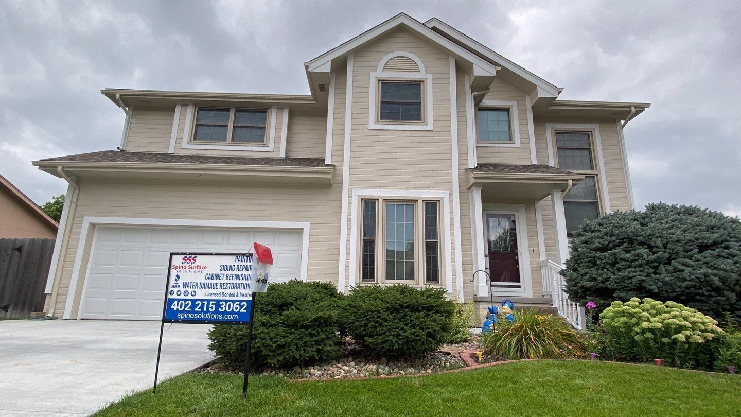 A large house with a for sale sign in front of it.