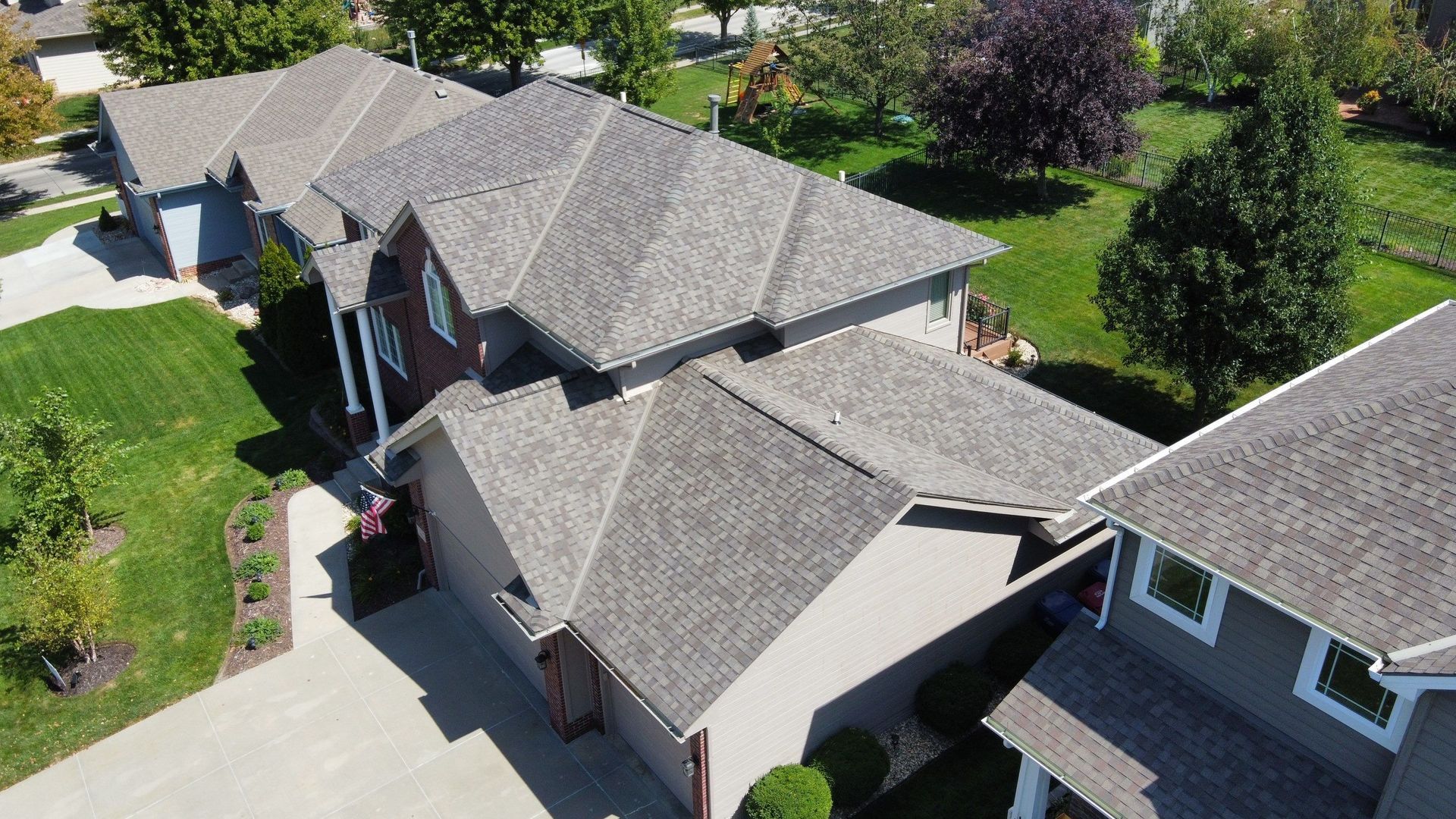 An aerial view of a house with a lot of windows and a roof.
