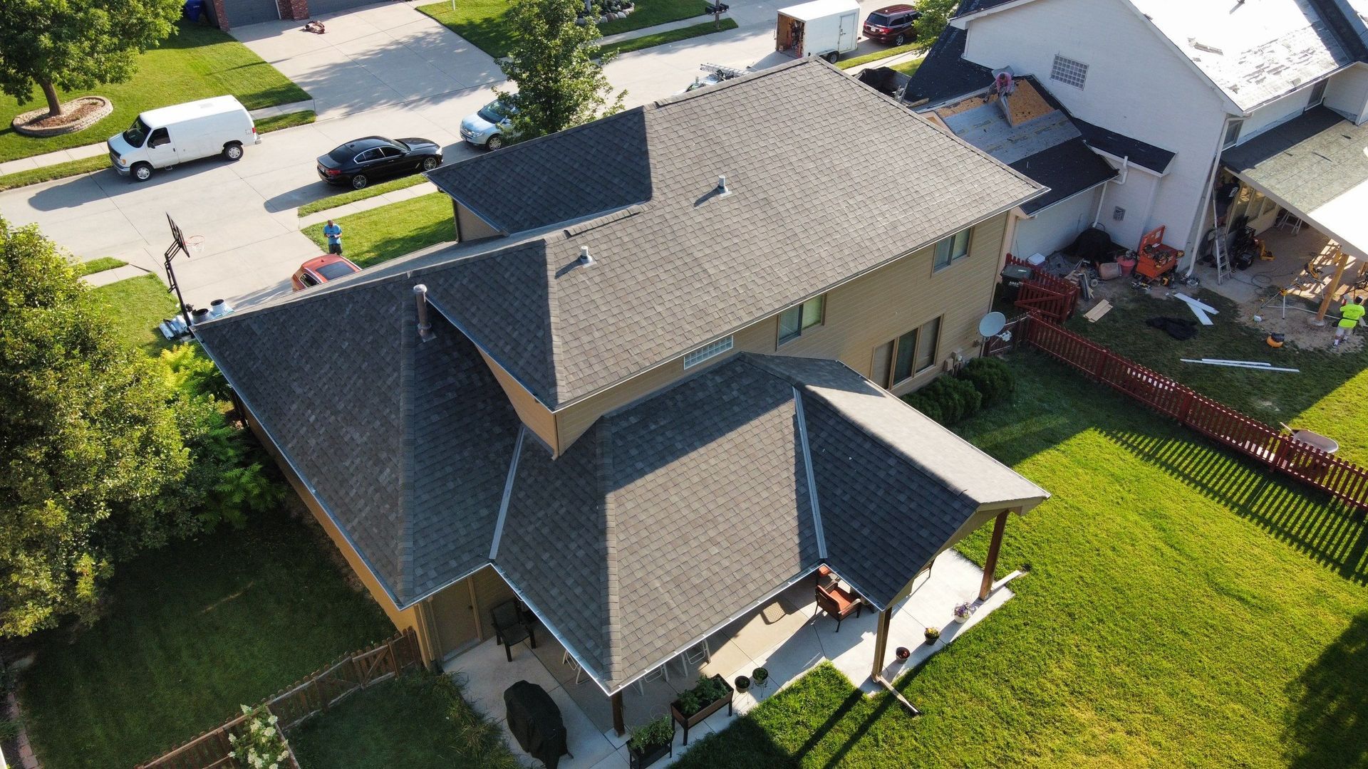 An aerial view of a house with a new roof in a residential area.