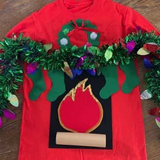 Red Christmas sweater with fireplace, garland, and stockings.