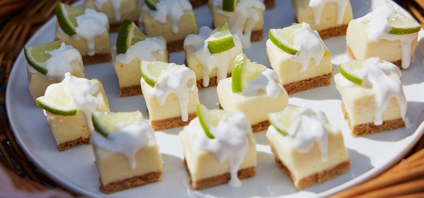 A white plate topped with key lime bites garnished with limes.