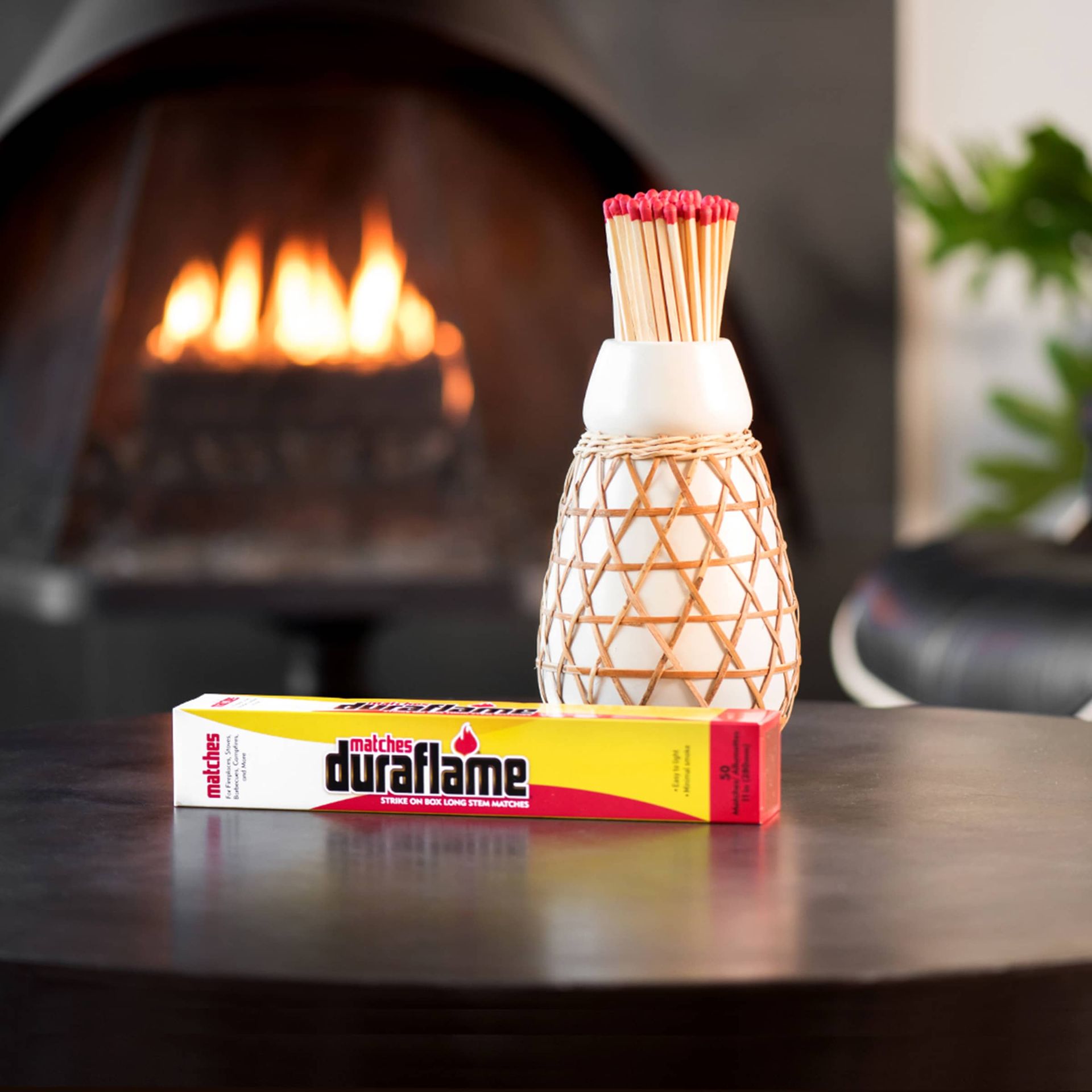 A box of duraflame safety long matches for fire sits on a table in front of a fireplace, long fireplace matches