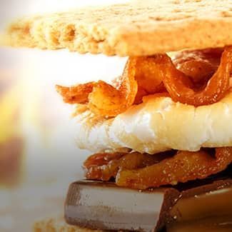 A close up of bacon s'mores with fire in background