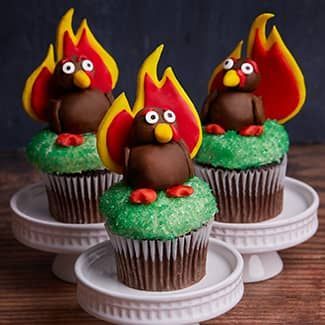 3 Thanksgiving chocolate cupcakes with turkeys on top, the duraflame flame logo as their feathers
