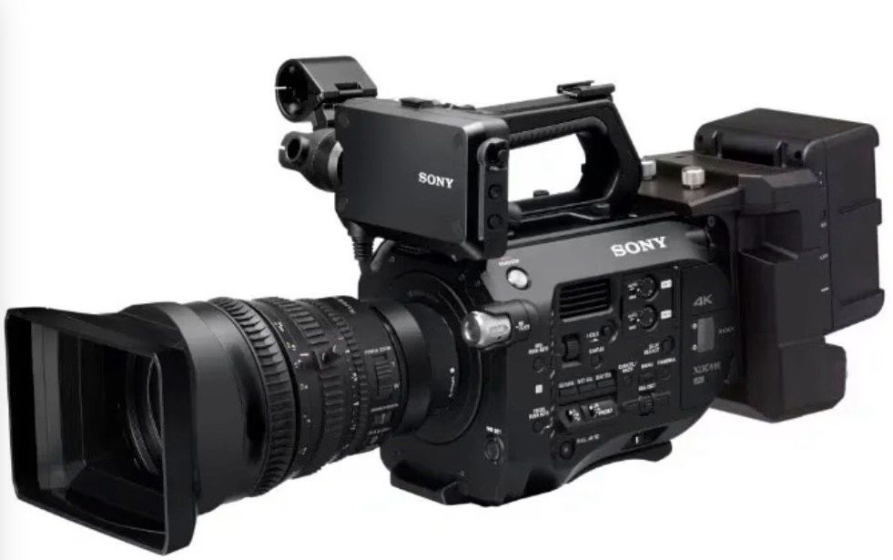 A black professional Sony cinema camera with a large zoom lens and a top-mounted handle, shown against a white background.
