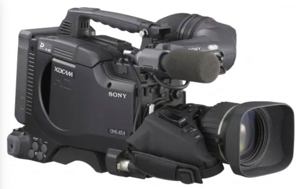A professional black Sony XDCAM shoulder-mount video camera with a lens hood and external microphone attached.