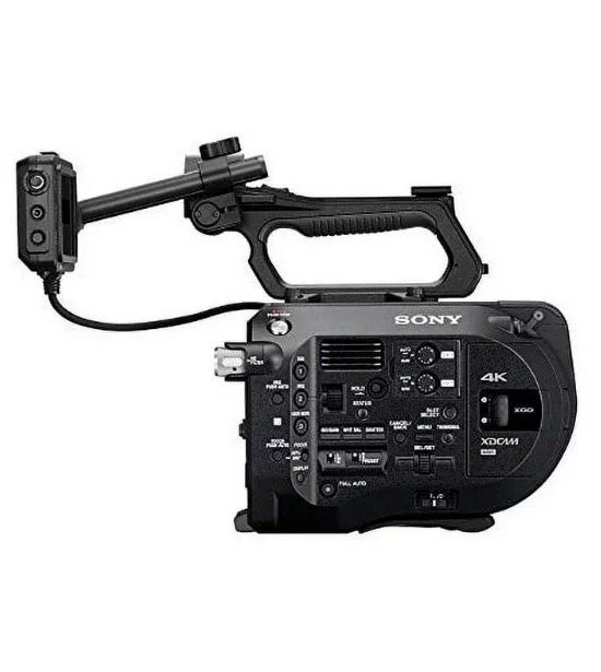 A side view of a black Sony 4K professional video camera body with its top handle and remote control unit attached.