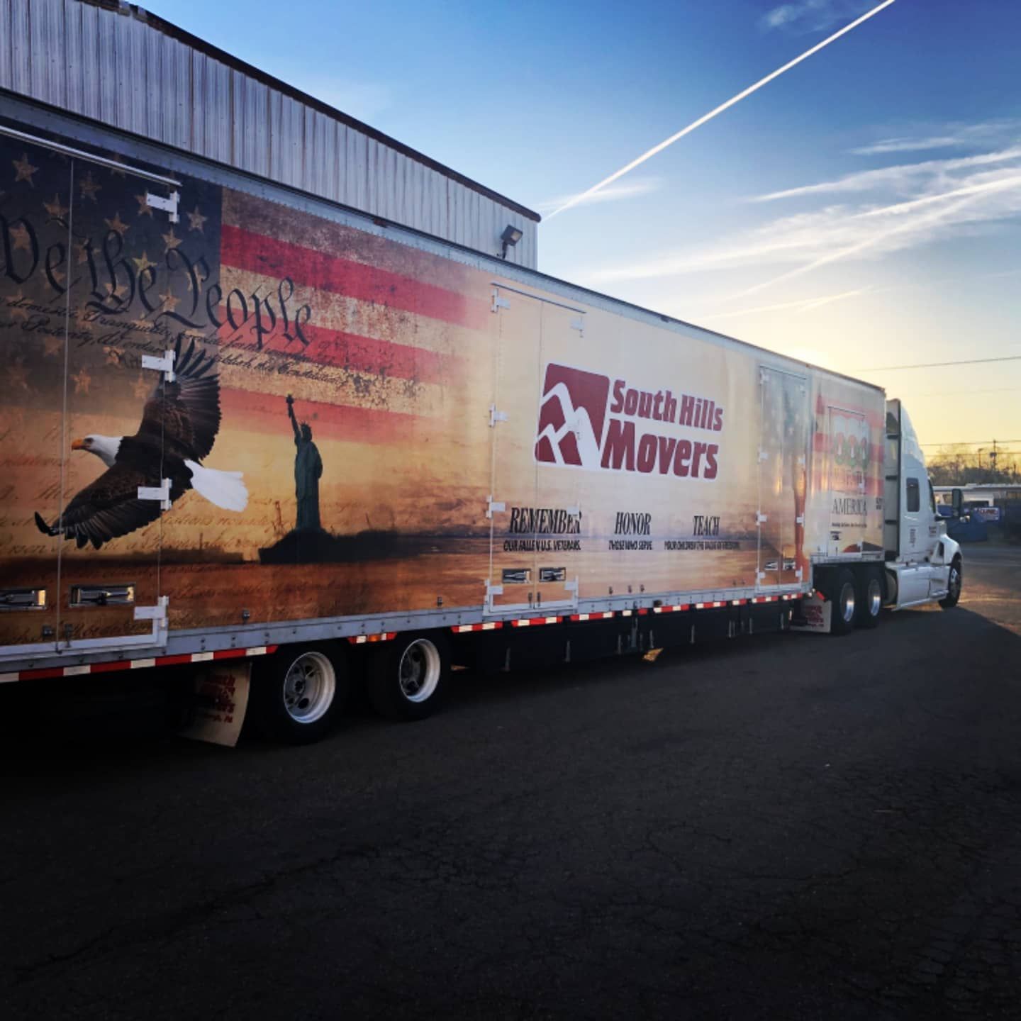 South Hills Movers truck with American flag graphic and eagle, parked on asphalt.